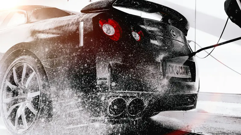 Pressure washing a sports car covered in snow foam